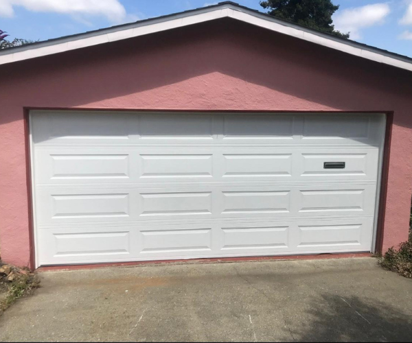Garage door repair technicians replacing a broken spring in Oakland