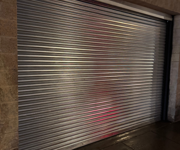 Commercial Garage door repair technicians replacing a broken spring in Oakland