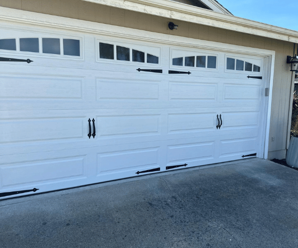 Garage door repair technicians replacing a broken spring in Alameda